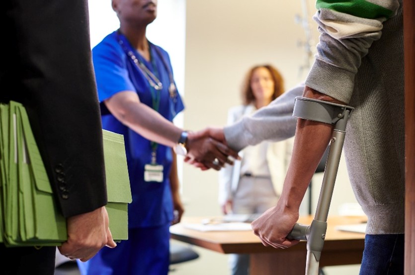 Lawyer standing beside client before a personal injury medical assessment